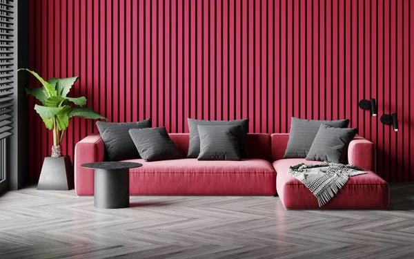 Imagem de uma sala de estar com painel ripado de madeira pintado na cor Magenta e sofá na mesma cor com almofadas cinzas.