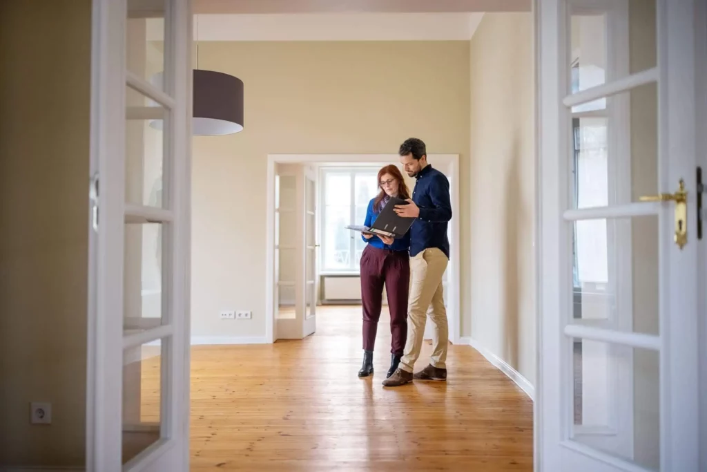 Imagem de um casal analisando documentos da casa antes de assinar o contrato para ilustrar matéria sobre comprar ou alugar casa