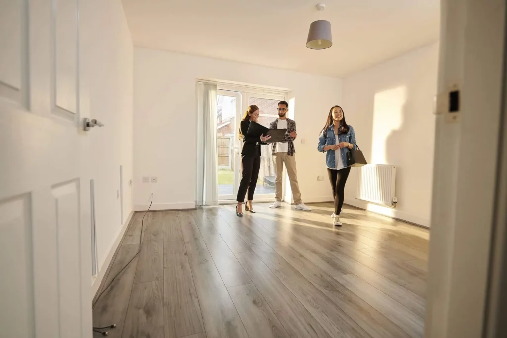 Imagem de um agente imobiliário mostrando um imóvel para um casal formado por um homem e uma mulher para ilustrar matéria sobre financiar ou alugar