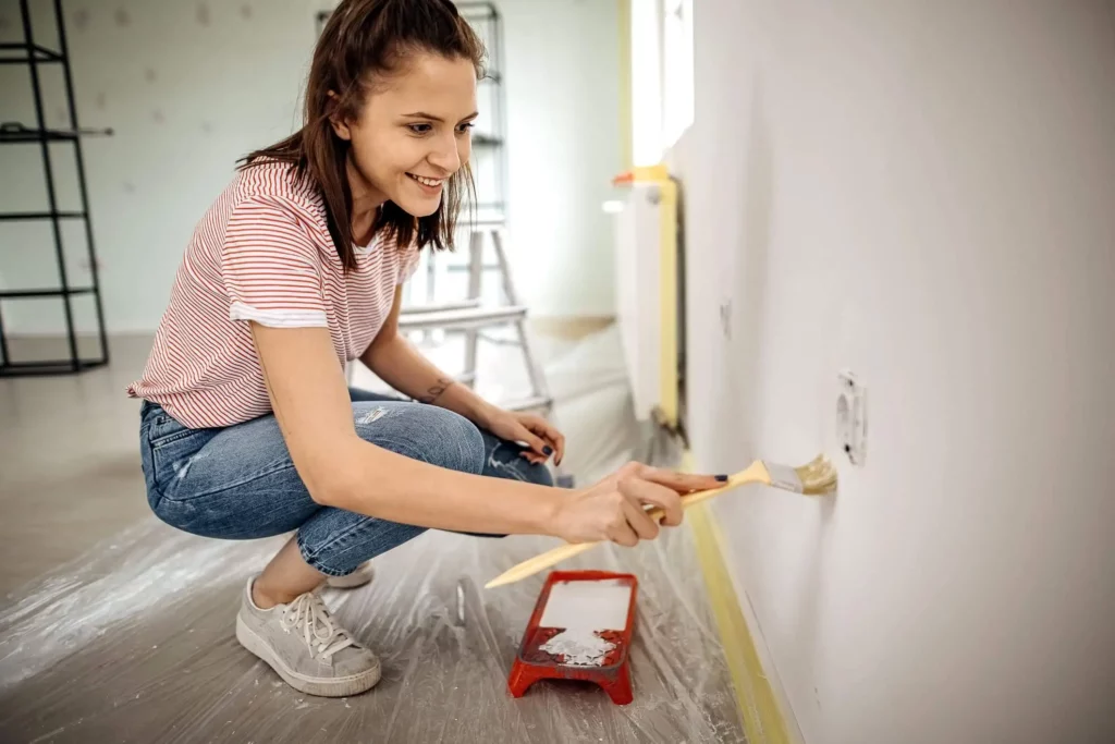 Imagem de uma mulher pintando a parede de um apartamento para ilustrar matéria sobre como vender um imóvel mais rápido