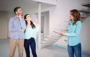 Imagem de um casal visitando um apartamento com um vistoriador durante a vistoria para ilustrar matéria sobre o laudo de vistoria de imóvel
