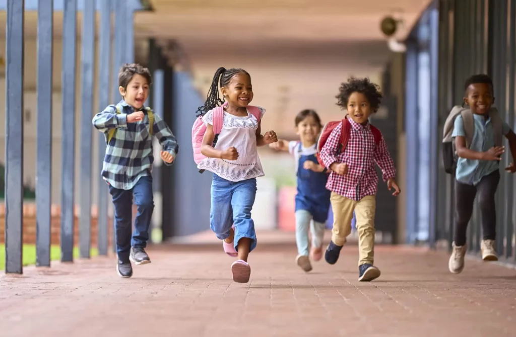 Imagem de crianças correndo no corredor de uma escola para ilustrar matéria sobre as melhores escolas particulares de SP