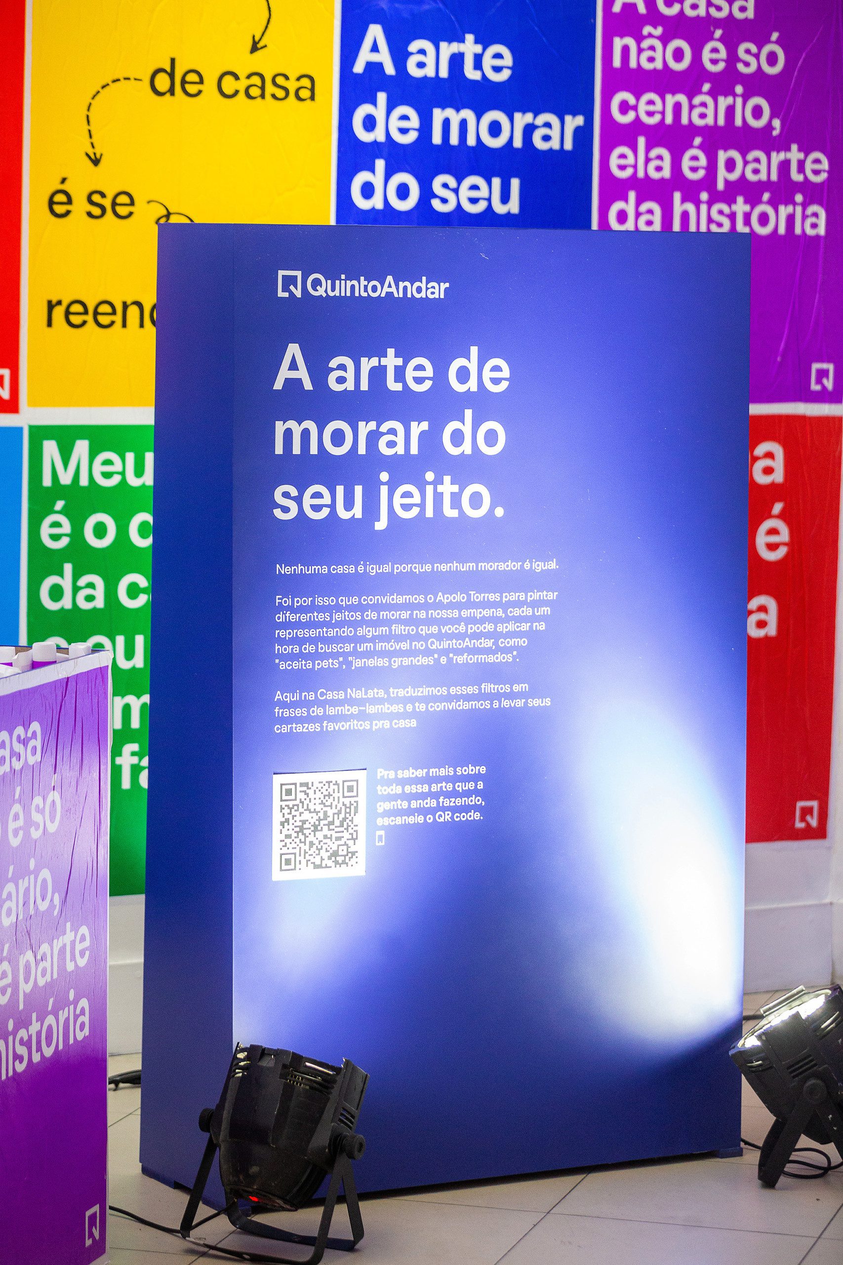 Foto que ilustra matéria sobre NaLata Festival mostra ação do QuintoAndar dentro da Casa NaLata com lambe-lambes coloridos com frases sobre o morar