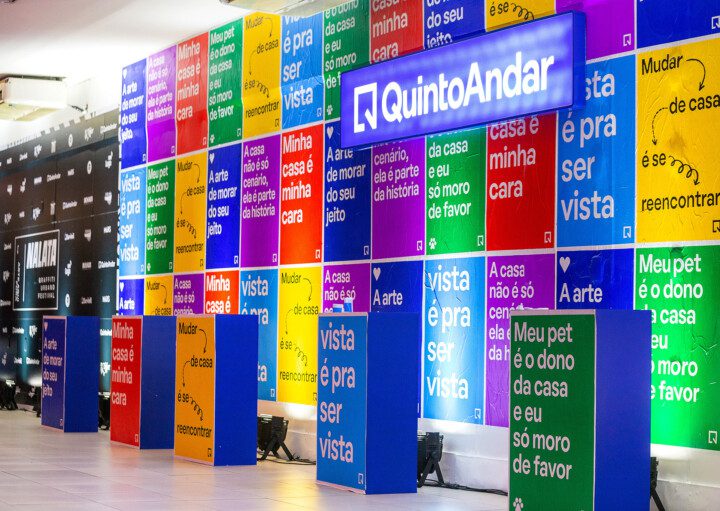 Foto que ilustra matéria sobre NaLata Festival mostra ação do QuintoAndar dentro da Casa NaLata com lambe-lambes coloridos com frases sobre o morar