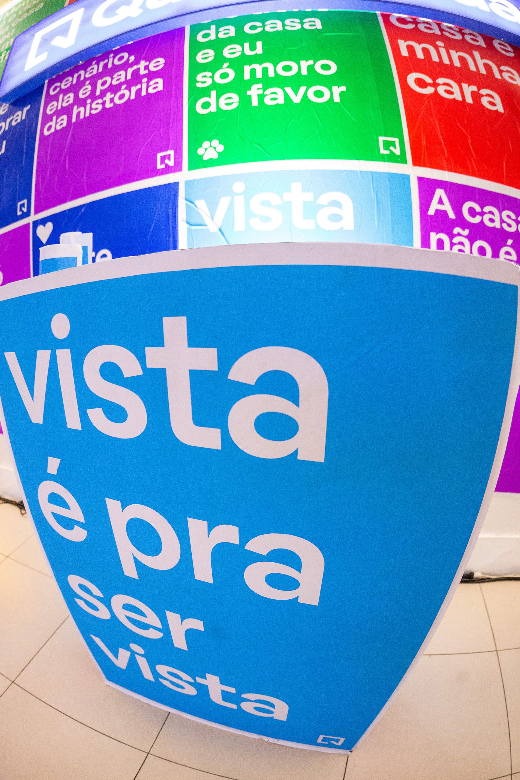 Foto que ilustra matéria sobre NaLata Festival mostra ação do QuintoAndar dentro da Casa NaLata com lambe-lambes coloridos com frases sobre o morar