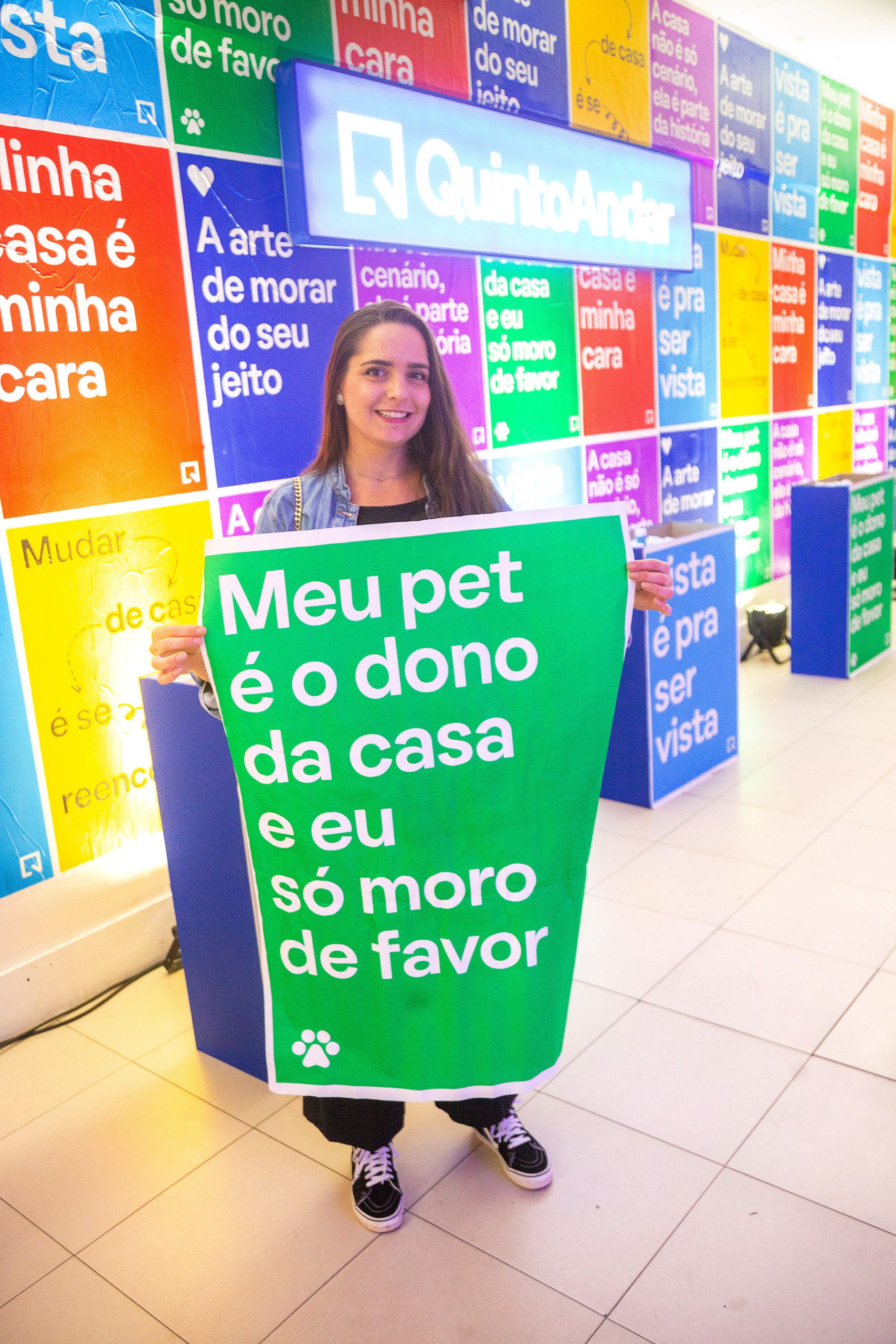 Foto que ilustra matéria sobre NaLata Festival mostra ação do QuintoAndar dentro da Casa NaLata com lambe-lambes coloridos com frases sobre o morar