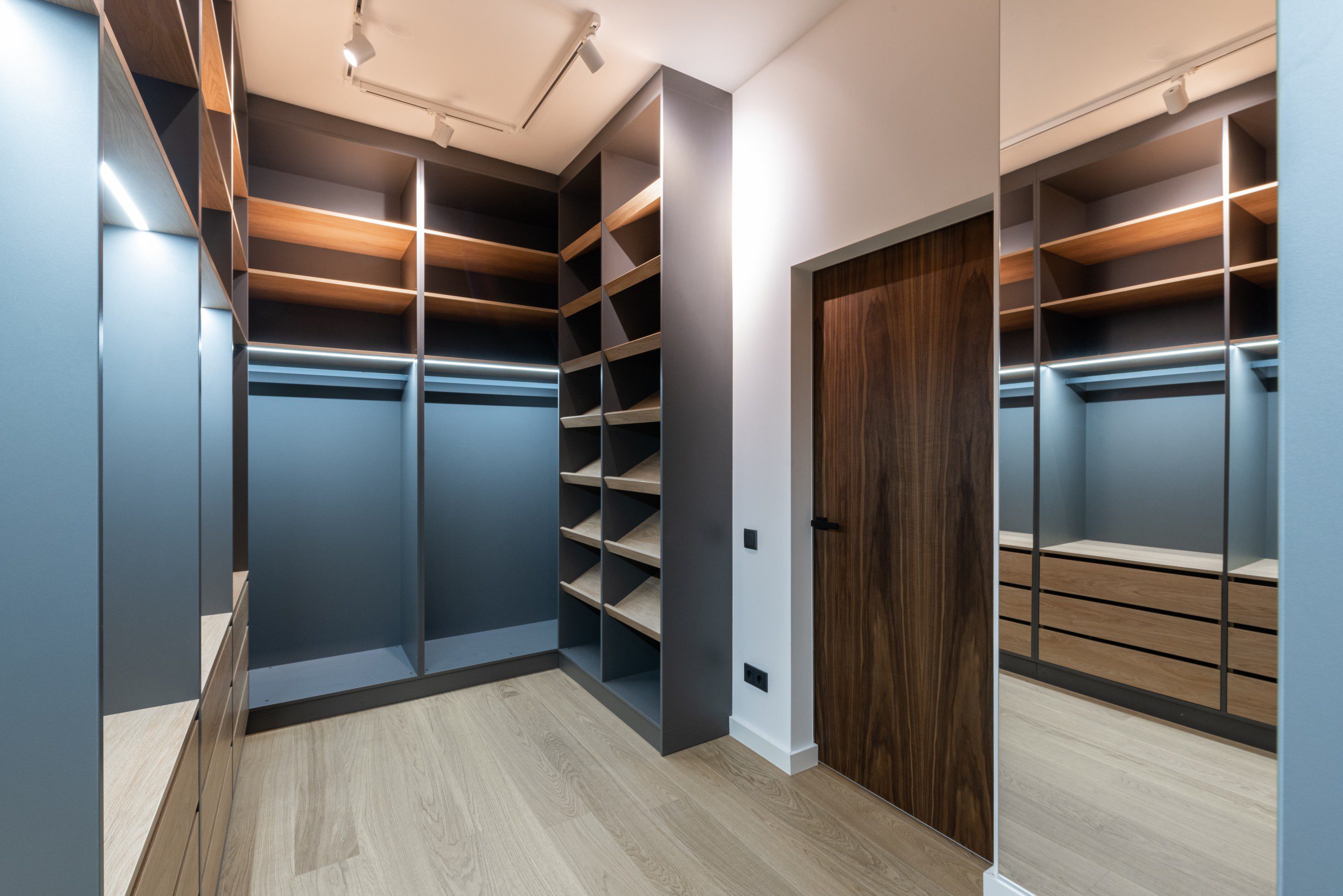 Imagem de um closet em tons de preto e tons amadeirados planejado feito sob medida.