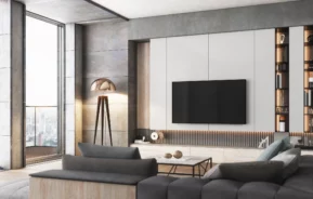 Imagem da decoração de luxo de uma sala de estar mostra sofás, racks, tv e objetos decorativos para ilustrar matéria sobre ideias de rack para sala