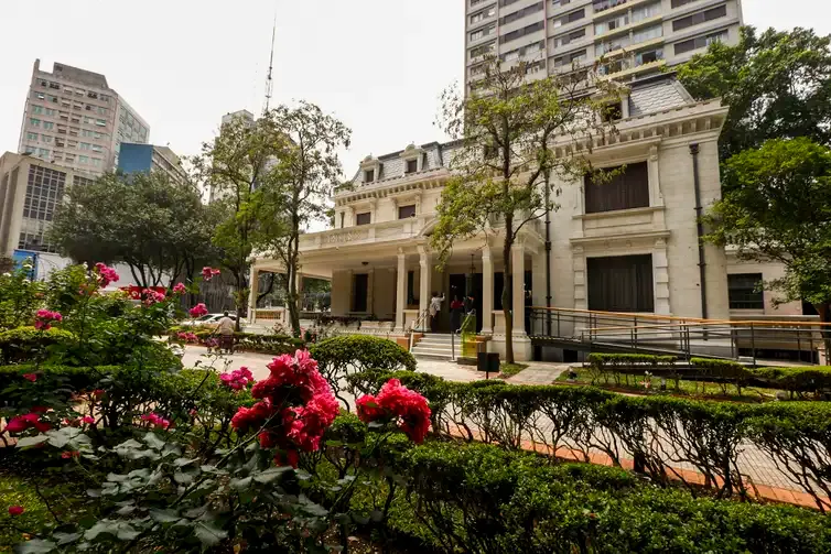 Imagem da Casa das Rosas, uma histórica mansão branca com colunas e detalhes ornamentados na Avenida Paulista, para ilustrar matéria sobre os museus de graça em São Paulo