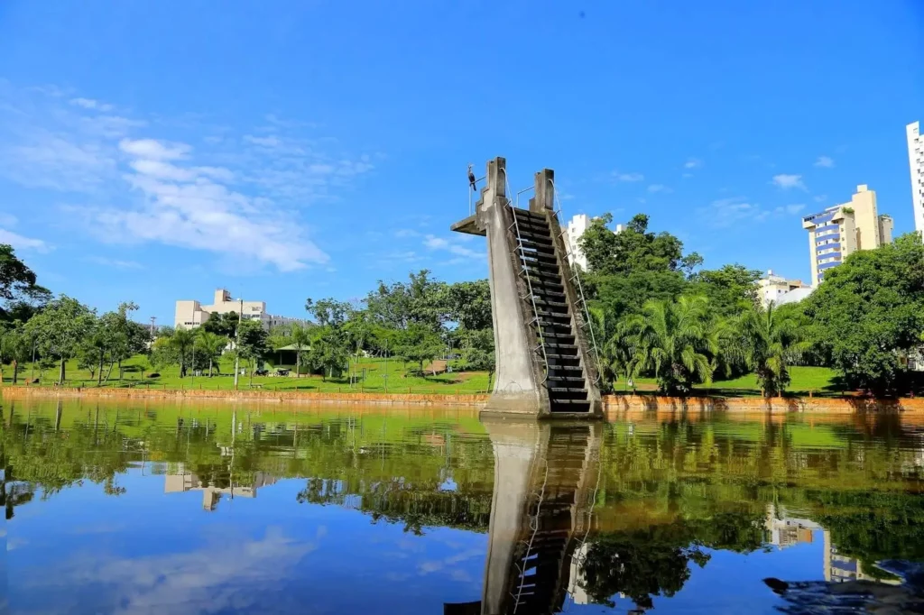 Imagem do lago do Lago das Rosas. Há uma escada dentro da água e vegetação ao fundo.