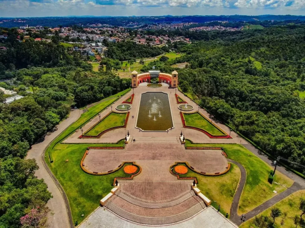 Imagem da vista aérea do Parque Tanguá, em Curitiba, cercado por vegetação e prédios da cidade ao fundo, para ilustrar matéria sobre o que fazer em Curitiba em 3 dias