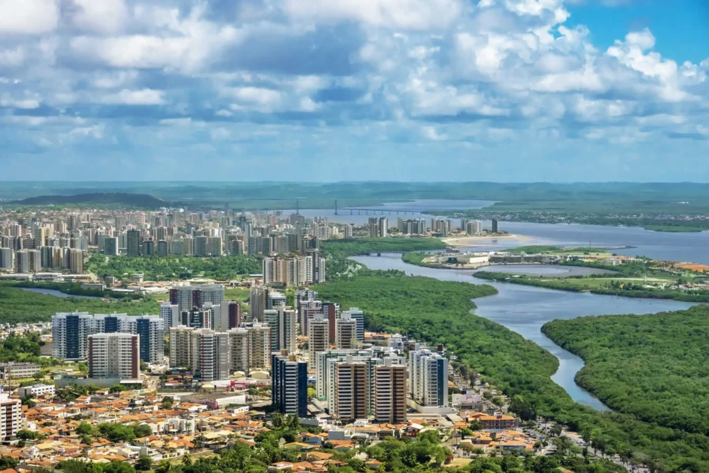 Imagem da vista aérea de Aracaju mostra prédios, vegetação e mar para ilustrar matéria sobre a melhor capital para morar no Brasil