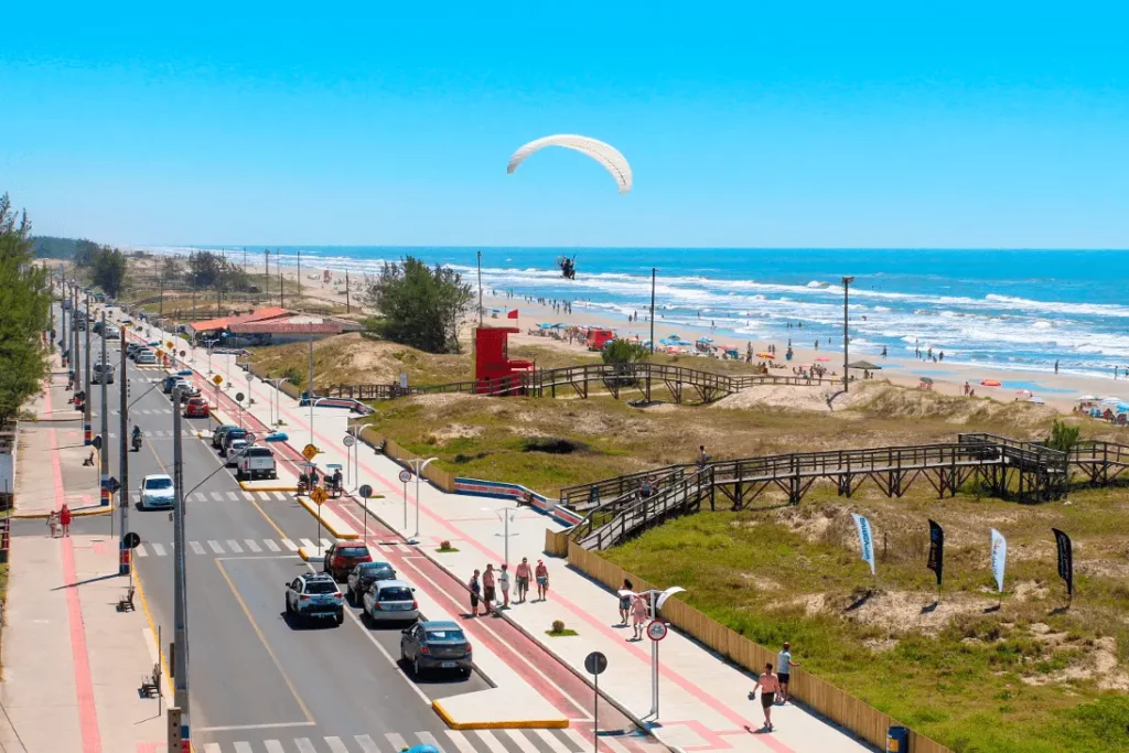 Imagem da vista aérea de Balneário Gaivota mostra praias, ruas e pedestres para ilustrar matéria sobre qual é a cidade que mais cresce no Brasil
