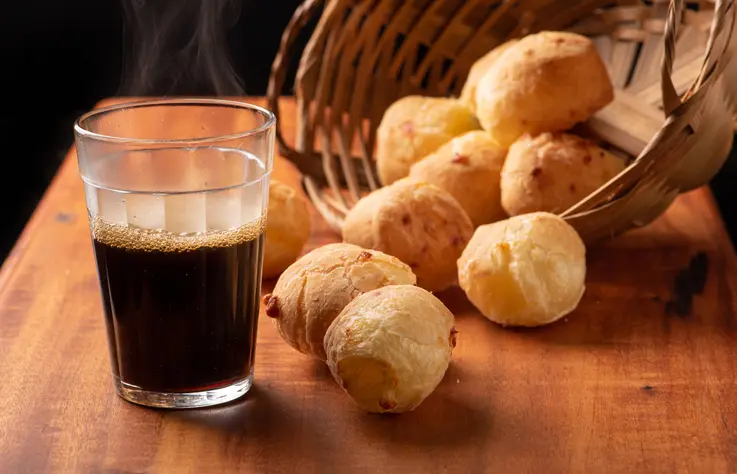 Foto de pão de queijo e café preto.