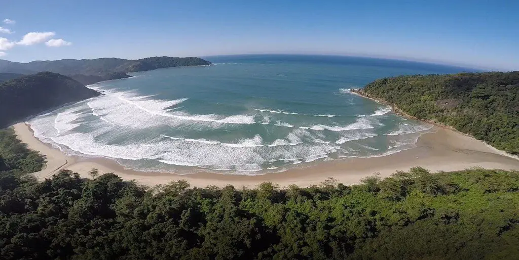 Imagem aérea da Praia Brava do Camburi, em Ubatuba, mostra praia deserta cercada por vegetação para ilustrar matéria sobre qual é a praia mais próxima de São Paulo