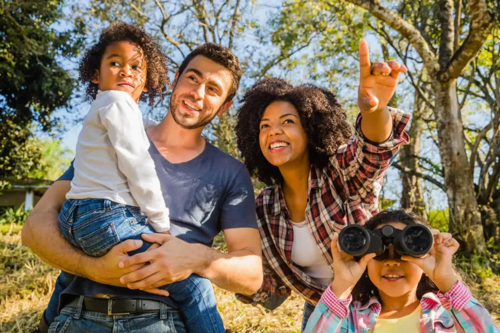 Imagem de uma família com um pai, uma mãe e duas crianças se divertindo em meio a natureza para ilustrar matéria sobre por que morar no Triângulo Mineiro