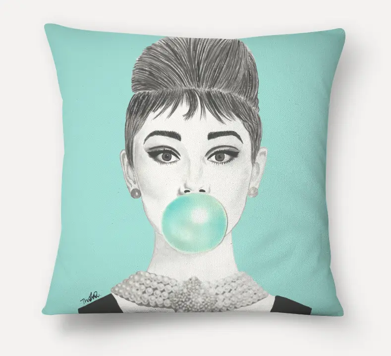 Uma almofada decorativa perfeita para almofadas de sofá, com um desenho em preto e branco de uma mulher com um penteado elegante, colar de pérolas e brincos, soprando uma grande bolha de chiclete azul-água contra um fundo azul-claro.