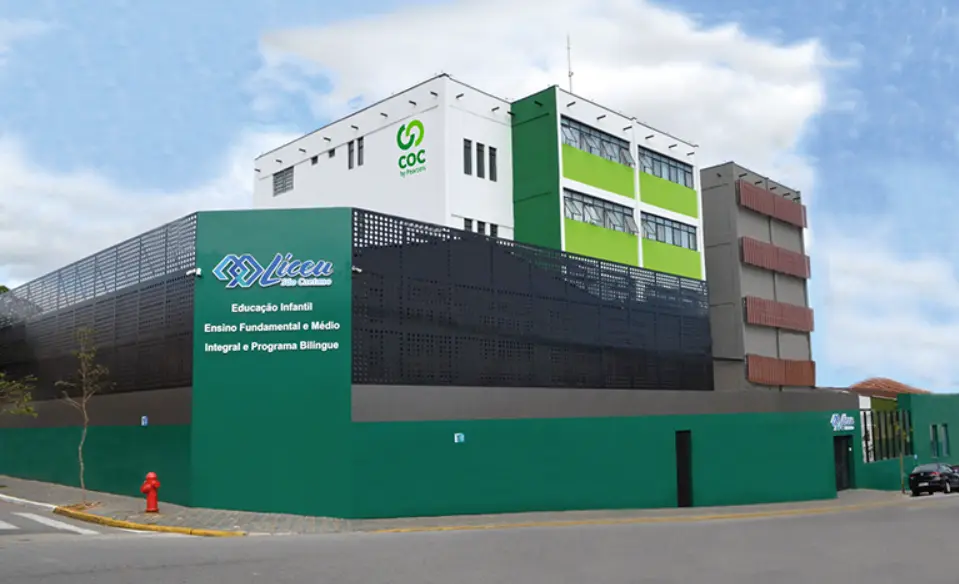Um prédio escolar moderno, de vários andares, com detalhes em verde e branco, denominado COC e Liceu — uma das escolas de destaque em São Caetano. A entrada apresenta uma parede verde, uma tela preta perfurada e um hidrante na calçada externa.