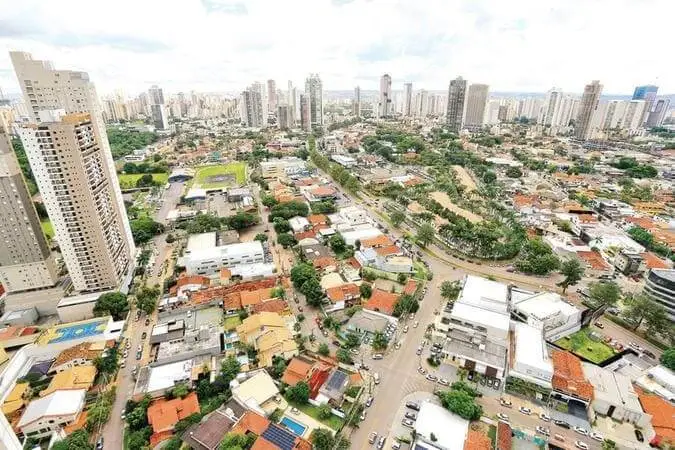Imagem da vista aérea do Setor Marista mostra arranha-céus altos, edifícios de médio porte e casas residenciais com telhados vermelhos aninhados entre árvores e estradas sob um céu parcialmente nublado para ilustrar matéria sobre os melhores bairros de Goiânia. Imagem: Wesley Costa/O Popular