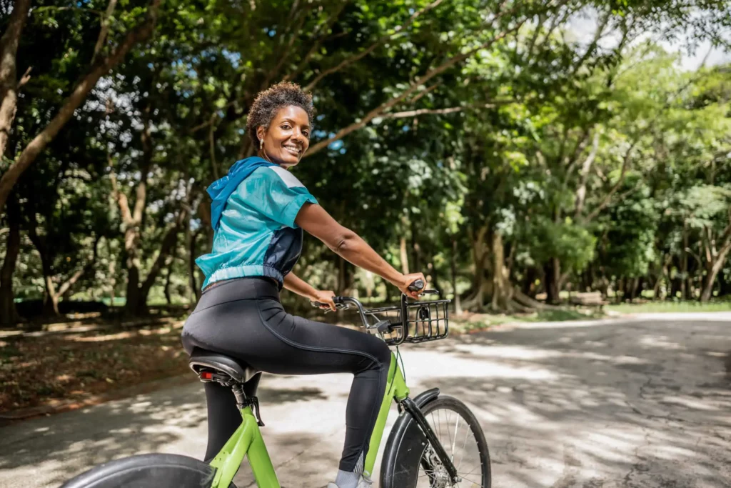 Imagem de uma mulher pedalando uma bicicleta em um parque público para ilustrar matéria sobre parques para andar de bicicleta em São Paulo