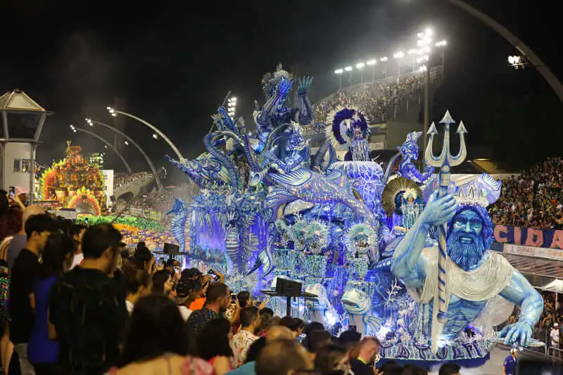 Imagem do desfile das escolas de samba no Sambódromo do Anhembi, em São Paulo, mostra carros alegóricos na passarela durante apresentação e público nas arquibancadas para ilustrar matéria sobre as cidades com o melhor carnaval