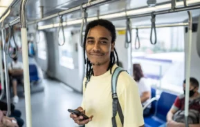 Imagem de um jovem usando o telefone dentro do trem do metrô para ilustrar matéria sobre a estação São Judas
