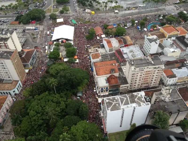 Imagem da vista aérea de Florianópolis mostra multidão cercando um palco em um bloco de rua em Florianópolis para ilustrar matéria sobre a melhor cidade de carnaval