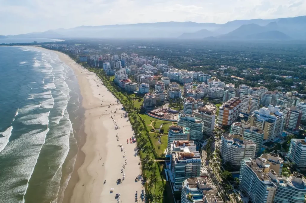 Imagem aérea com vista para prédios residenciais ao redor da praia em Bertioga para ilustrar matéria sobre cidades com IPTU mais caro no Brasil
