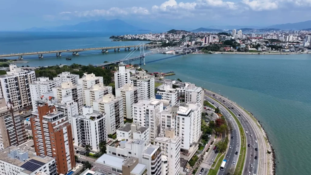 Imagem aérea de prédios residenciais de diferentes tamanhos cercados por mar em Florianópolis para ilustrar matéria sobre os projetos de cidades inteligentes do Brasil