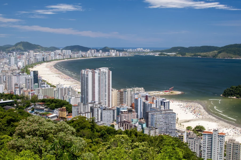 Imagem da paisagem urbana de Santos mostra prédios, faixa de areia e mar