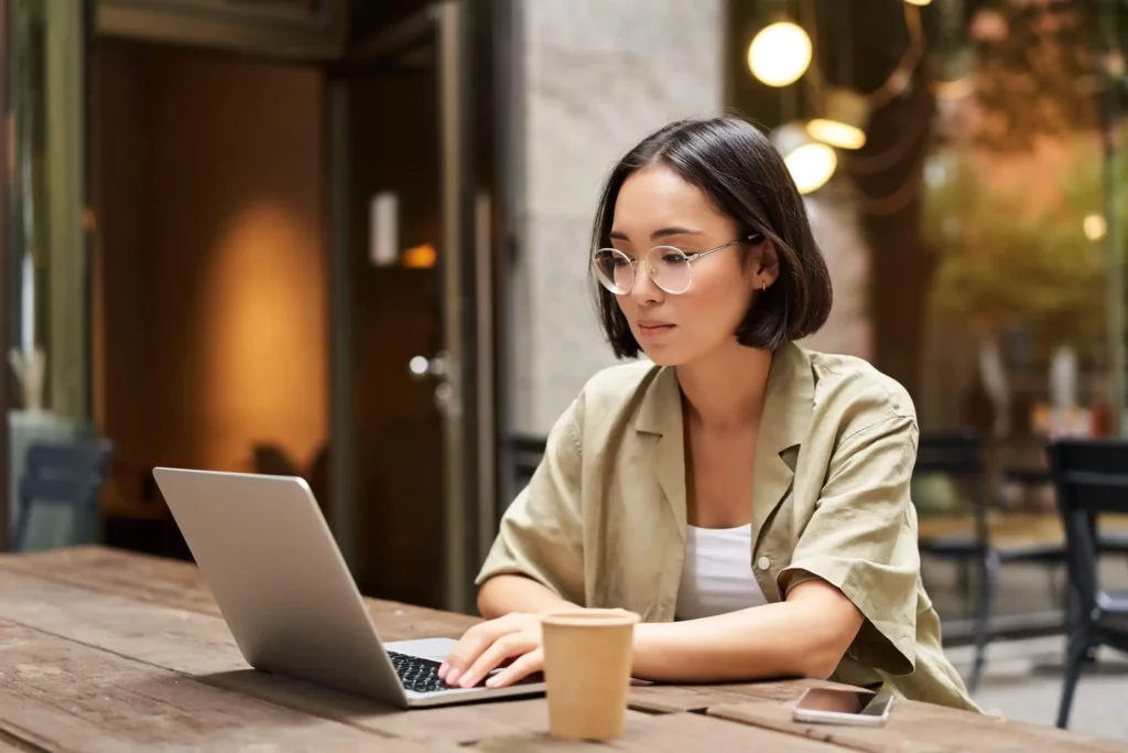 Imagem de uma mulher jovem contratada enquanto digita em um computador para ilustrar matéria sobre espaço coworking gratuito em SP