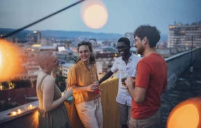 Imagem de um grupo de amigos em uma festa na cobertura de um prédio para ilustrar matéria sobre rooftop em São Paulo