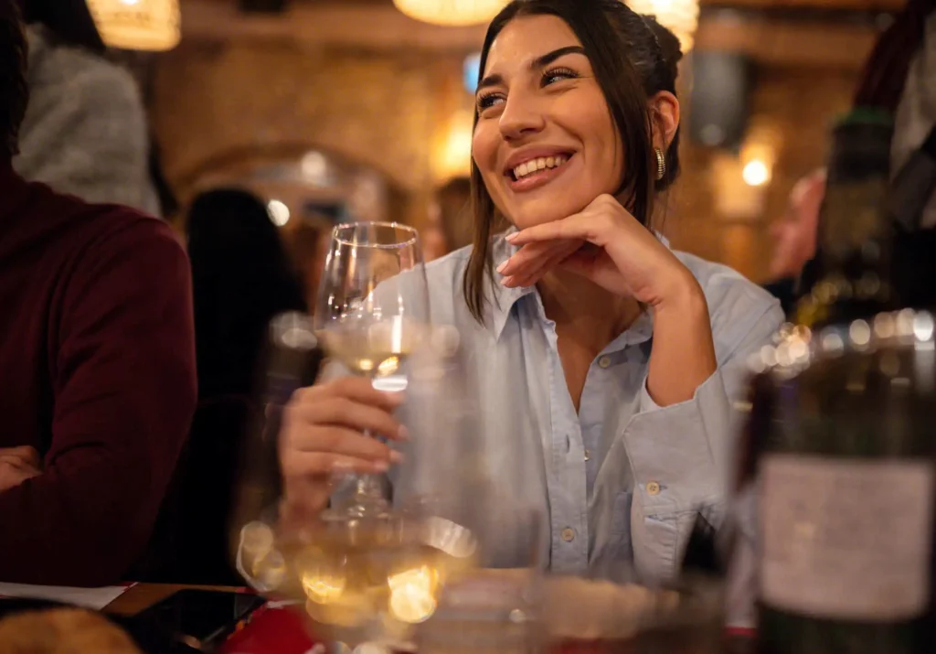 Imagem de uma mulher com uma taça de vinho em um restaurante a noite