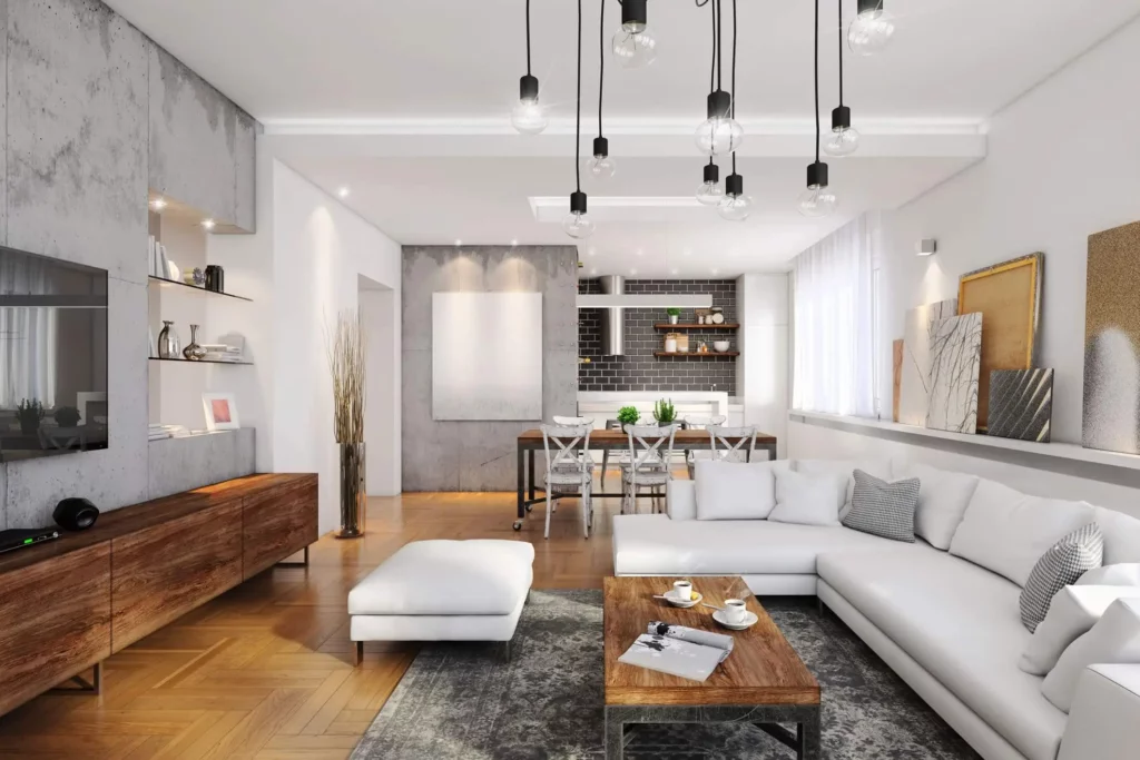 Imagem de um apartamento de alto padrão mostra uma sala de estar moderna com sofá seccional branco, móveis de madeira, luminárias penduradas com lâmpadas expostas, decoração neutra, arte na parede e uma área de jantar aberta com detalhes em preto e janelas grandes que permitem a entrada de luz natural