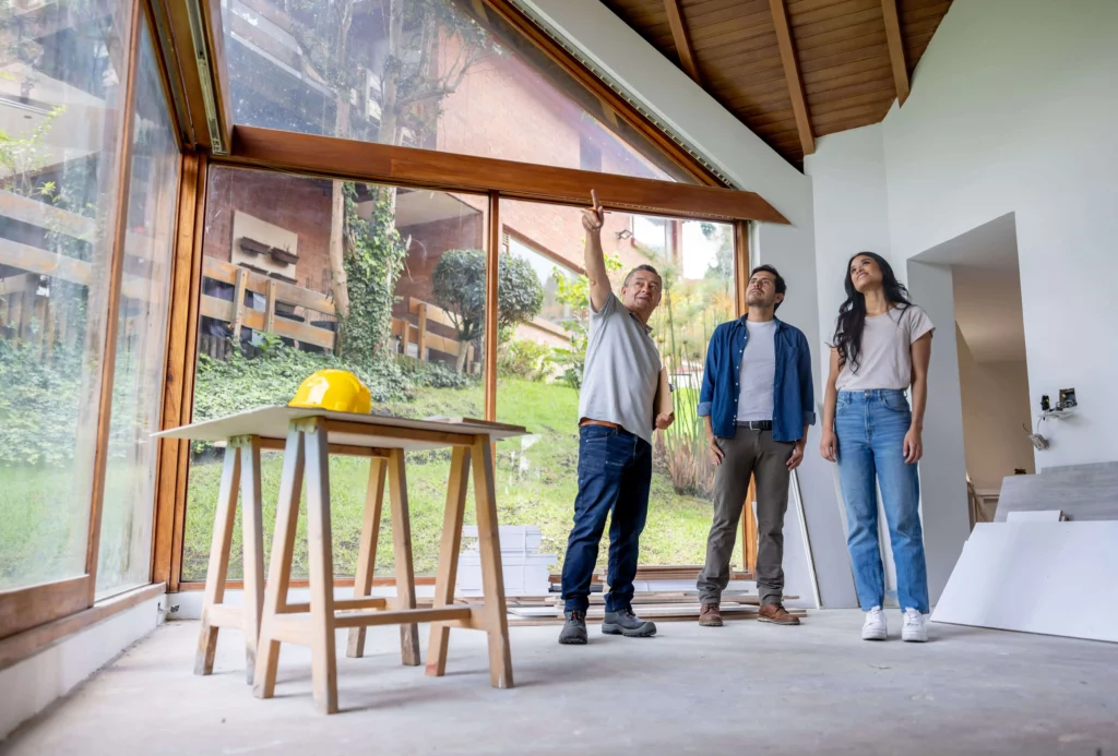 Imagem de um empreiteiro conversando com clientes que estão reformando a casa para ilustrar matéria sobre o requerimento para averbação