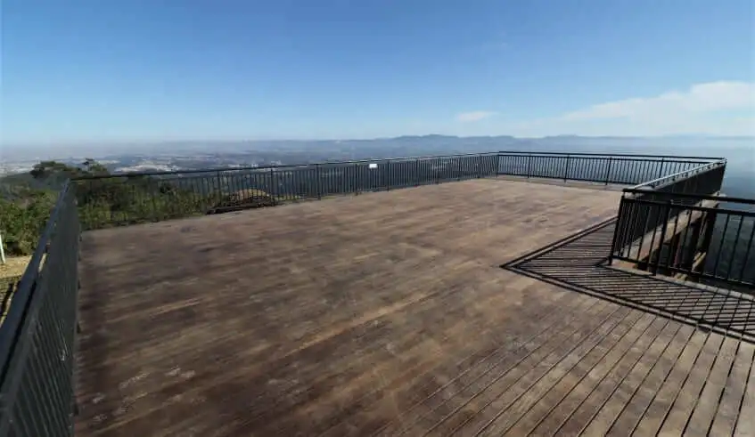 Imagem do deck de madeira do Pico do Urubu, em Mogi das Cruzes, com vista para a cidade ao fundo.